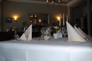 una mesa blanca con copas de vino y servilletas. en Gutshaus Redewisch Hotel & Restaurant, en Boltenhagen