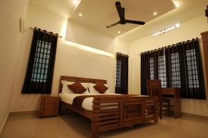 a bedroom with a bed and a ceiling fan at Budget Appartments Thekkady in Thekkady