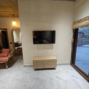 a living room with a flat screen tv on a wall at Aaryavan, A boutique resort in Mount Ābu