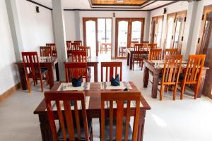 a dining room with wooden tables and chairs at Oudomsin Guesthouse in Luang Prabang