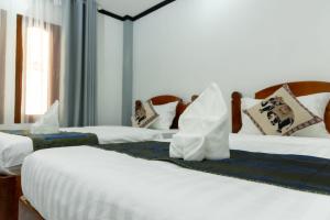 a group of three beds in a room at Oudomsin Guesthouse in Luang Prabang