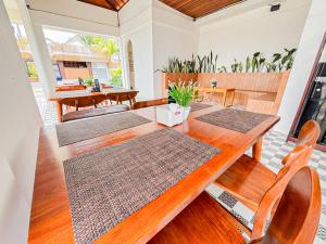 a dining room with a wooden table and chairs at Winners surfing bali resort in Airsatang