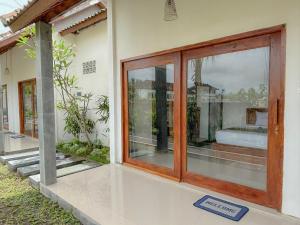 a room with a sliding glass door on a house at Winners surfing bali resort in Airsatang