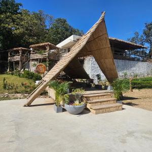 a house with a wooden roof with some plants at Aaryavan, A boutique resort in Mount Ābu +22 photos