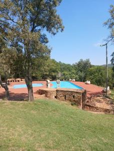 a swimming pool in a yard with a tree at Picturesque 82 in Buffelspoort