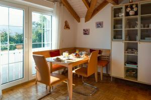 a dining room with a wooden table and chairs at Armonia Altach, 2BR Familienapartment mit großem Balkon und Bergblick in Altach