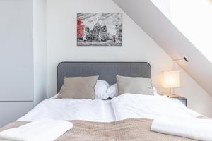 a bed with white sheets and a picture on the wall at 10-Min Walk to Hauptbahnhof, Cozy Private Rooms with AC, TV & WIFI in Vienna