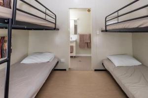 two bunk beds in a room with a bathroom at BIG4 Opal Holiday Park in Lightning Ridge
