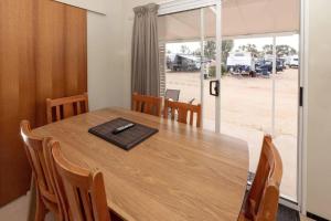 a dining room with a wooden table with chairs at BIG4 Opal Holiday Park in Lightning Ridge