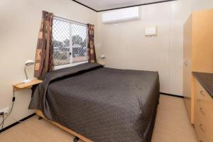 a bedroom with a large bed and a window at BIG4 Opal Holiday Park in Lightning Ridge