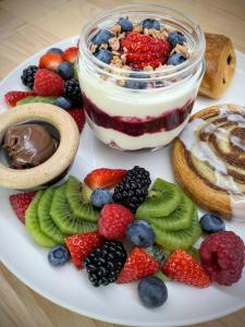 a plate of food with fruit and a jar of yogurt at Tullochard House B&B in Dunvegan