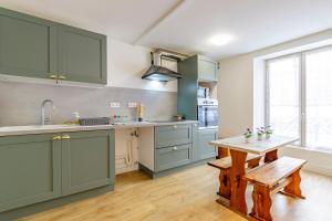 a kitchen with green cabinets and a wooden table at Cœur Historique, Duplex pour 5 in Issoudun