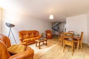 a living room with leather furniture and a table at Cœur Historique, Duplex pour 5 in Issoudun +6 photos