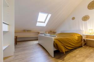 a attic bedroom with a bed and a window at Cœur Historique, Duplex pour 5 in Issoudun