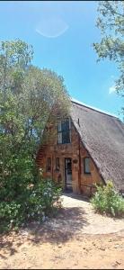 a wooden barn with a door and a tree at Picturesque 82 in Buffelspoort