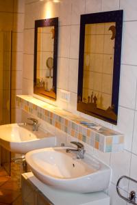a bathroom with two sinks and two mirrors at Im Obsthaus 9 in Göhl +15 photos
