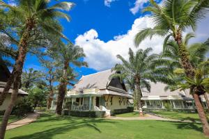 a house with palm trees in front of it at La Solaya Khao Lak in Khao Lak