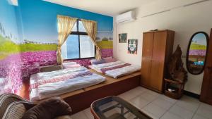 a bedroom with two beds and a window at 山頂洞人 in Fengyuan