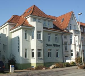 
a large white building with a blue roof at Hotel Willert in Wismar
