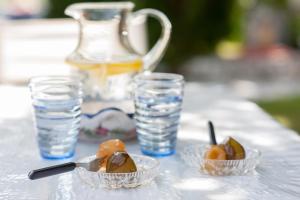 einen Tisch mit zwei Schalen Obst und Gläsern Wasser in der Unterkunft Dioni Houses in Paralia Pantaleimonos