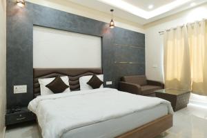 a bedroom with a large bed and a chair at Hotel Sunny Jhalawar in Jhālāwār +35 photos