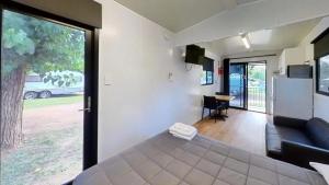 a room with a bed and a couch and a window at Camden Holiday Park in Camden