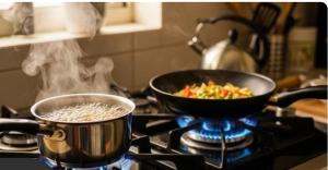 a pot of rice and a bowl of vegetables on a stove at Rahul Residency Homestay- Couple & Family friendly- 'prime location- Easy access to Mall Rd- WiFi- Smart TV - Kitchen- City view in Solan