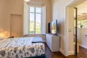 a bedroom with a bed and a flat screen tv at Lo Studiolo Fiesole in Fiesole