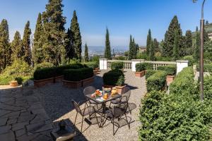 a patio with a table and chairs and trees at Lo Studiolo Fiesole in Fiesole