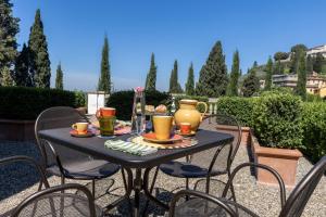 a black table with chairs and a table with food on it at Lo Studiolo Fiesole in Fiesole