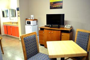 a room with a table and a television and a table and chairs at Hostal Universitario in San Germán