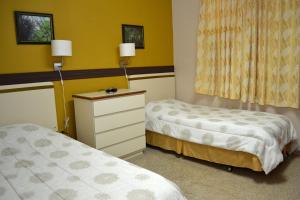 Pokój z 2 łóżkami i komodą w obiekcie Hostal Universitario w mieście San German