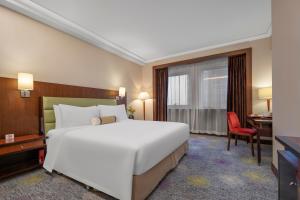 a bedroom with a large white bed and a desk at Ramada Plaza Pudong Shanghai in Shanghai +34 photos
