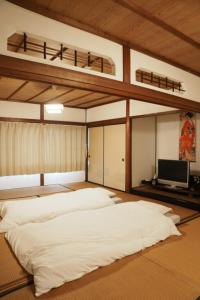 a bedroom with two bunk beds and a television at 8人宿泊可 子供添い寝無料 1日1組限定で開放感のある90平米 吉野山天川村40分 奈良大阪1時間 駅から徒歩5分 家主居住型 大淀桜庵 in Oyodo