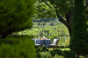 a table with two people sitting at it in a garden at Dioni Houses in Paralia Panteleimonos