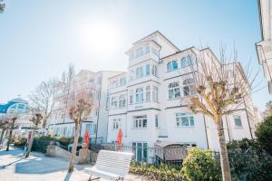 a white building with a bench in front of it at Hotel Villa Belvedere in Binz