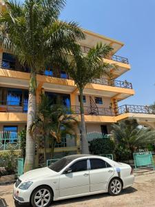 a white car parked in front of a building at Port Park Hotel in Mwanza
