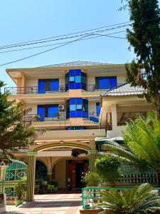 a large building with blue windows and palm trees at Port Park Hotel in Mwanza