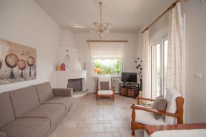 a living room with a couch and a television at Dioni Houses in Paralia Panteleimonos