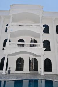 a white building with a pool in front of it at Ummaid palace, Siwan in Siwān
