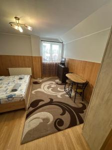 a bedroom with a table and a bed and a table and chair at Бордуляка 11 in Ternopil
