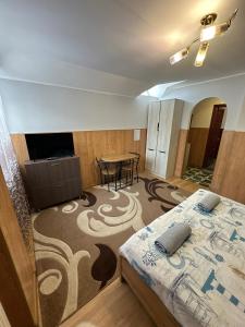 a room with a bed and a table in it at Бордуляка 11 in Ternopil