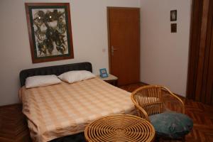 een kleine slaapkamer met een bed en een stoel bij Art Home in Prijedor
