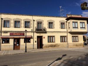 a large white building on the corner of a street at La Abuela Maye y Me in Carrión de los Condes