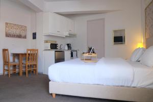 a bedroom with a large white bed and a kitchen at Eviali Apartments in Límni