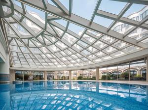 a large swimming pool with a glass ceiling at Renaissance Shanghai Hongqiao in Shanghai