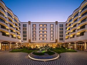 a large building with a fountain in front of it at Renaissance Shanghai Hongqiao in Shanghai