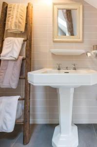 a bathroom with a sink and a shelf with towels at Le P'tit Clos in Vantoux +26 photos