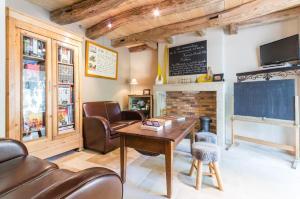 a living room with a table and a fireplace at Le P'tit Clos in Vantoux