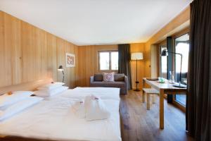 a hotel room with two beds and a desk at Krone Hittisau - Hotel & Restaurant im Bregenzerwald in Hittisau